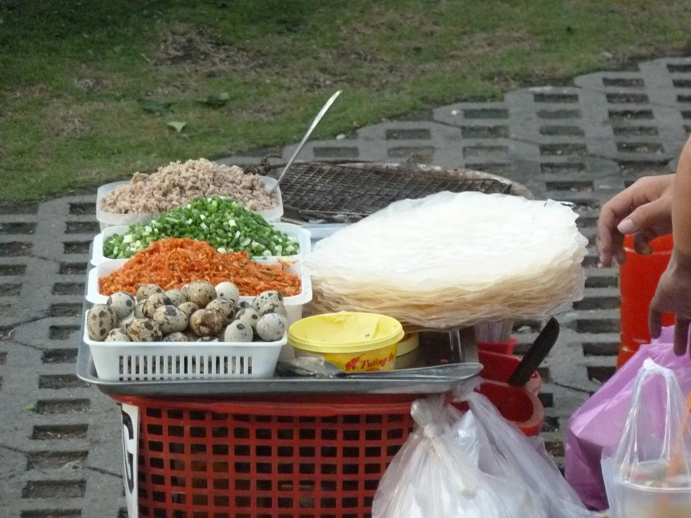 Street seller's basket with rice paper, herbs, dried shrimp and toppings for grilled rice paper snacks