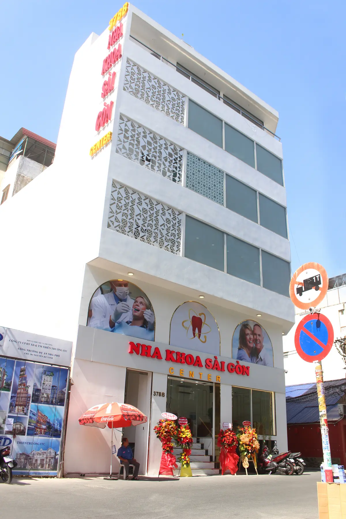 White clinic building with a red Nha Khoa Sai Gon Center sign above the ground floor.