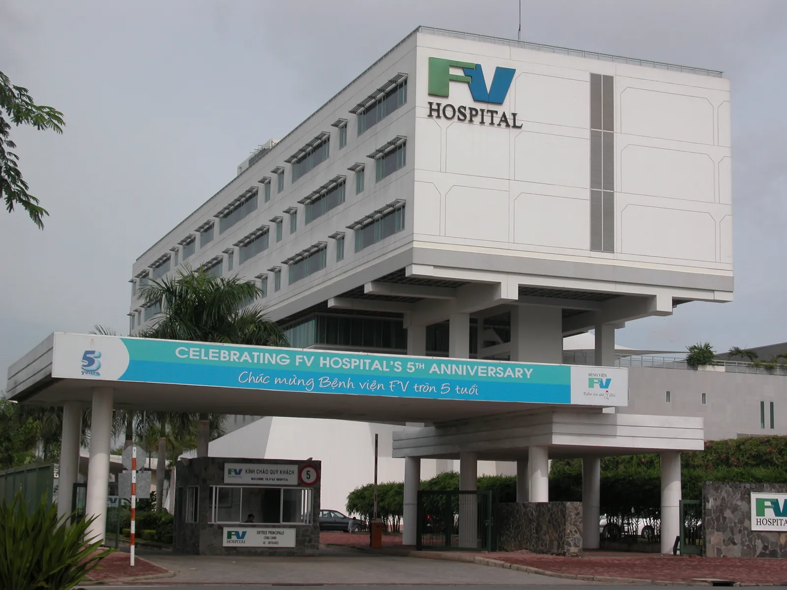 White hospital building with an FV Hospital sign above a covered entrance and a banner