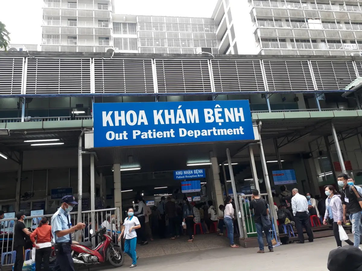Blue Out Patient Department sign above a crowded entrance at Cho Ray Hospital.