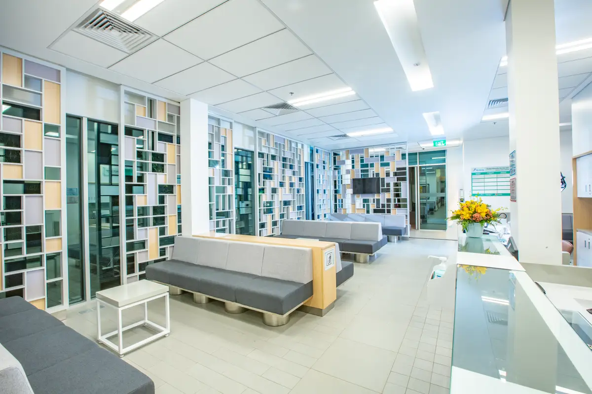 Bright waiting area at FV Hospital with built-in shelves, benches and a flower arrangement.