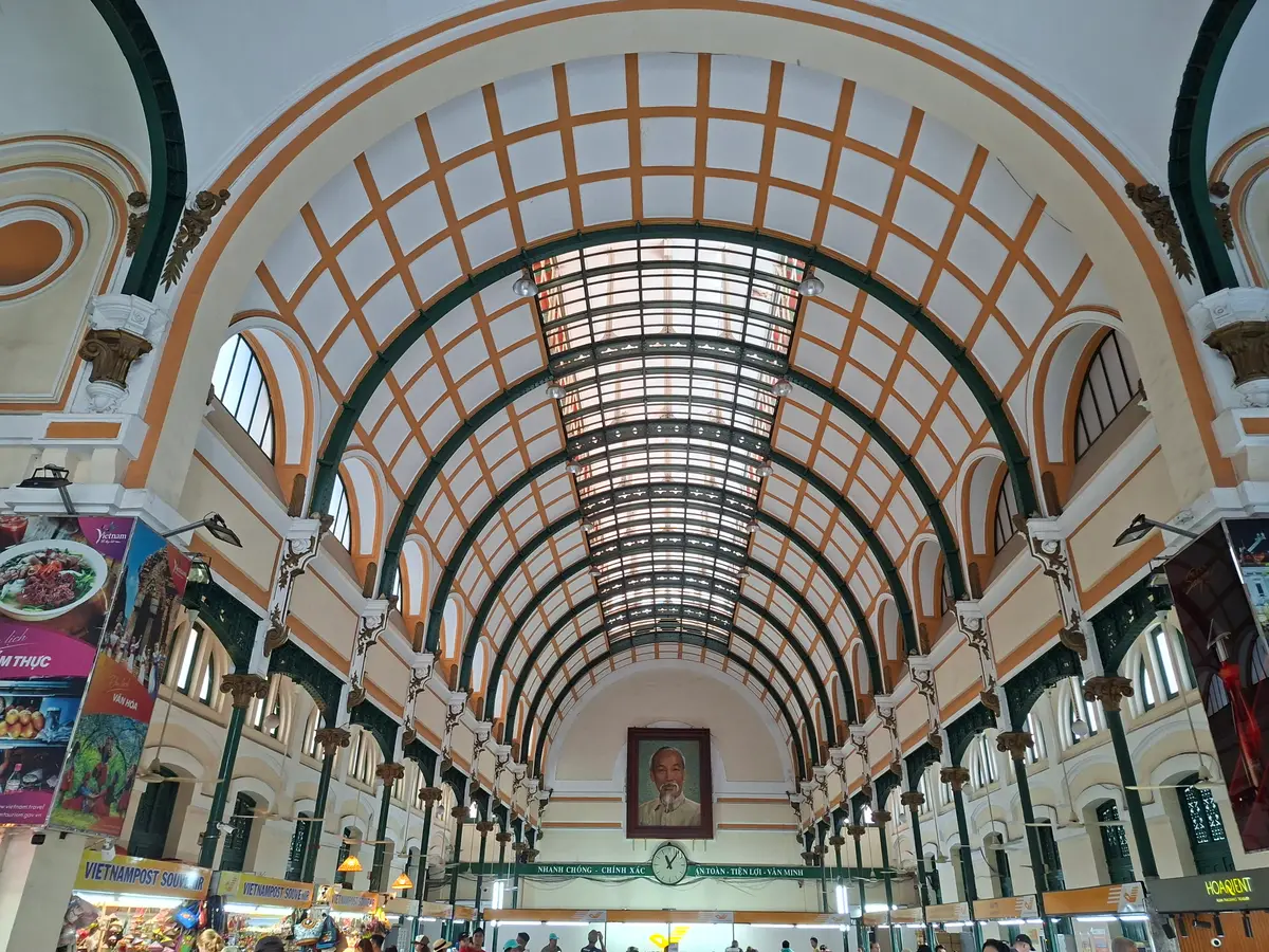 Long vaulted hall with a curved glass-and-iron ceiling and shop counters along the walls