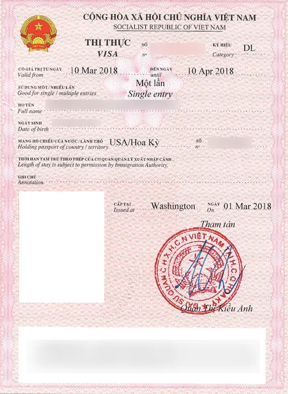 Loose-leaf Vietnam tourist visa with a red border, the national emblem, a red stamp and the holder's details blurred