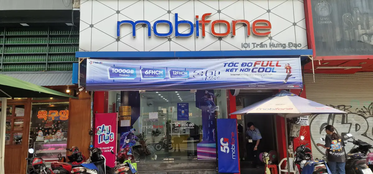 Shopfront of the MobiFone store on Tran Hung Dao Street with the blue and white logo above the glass door