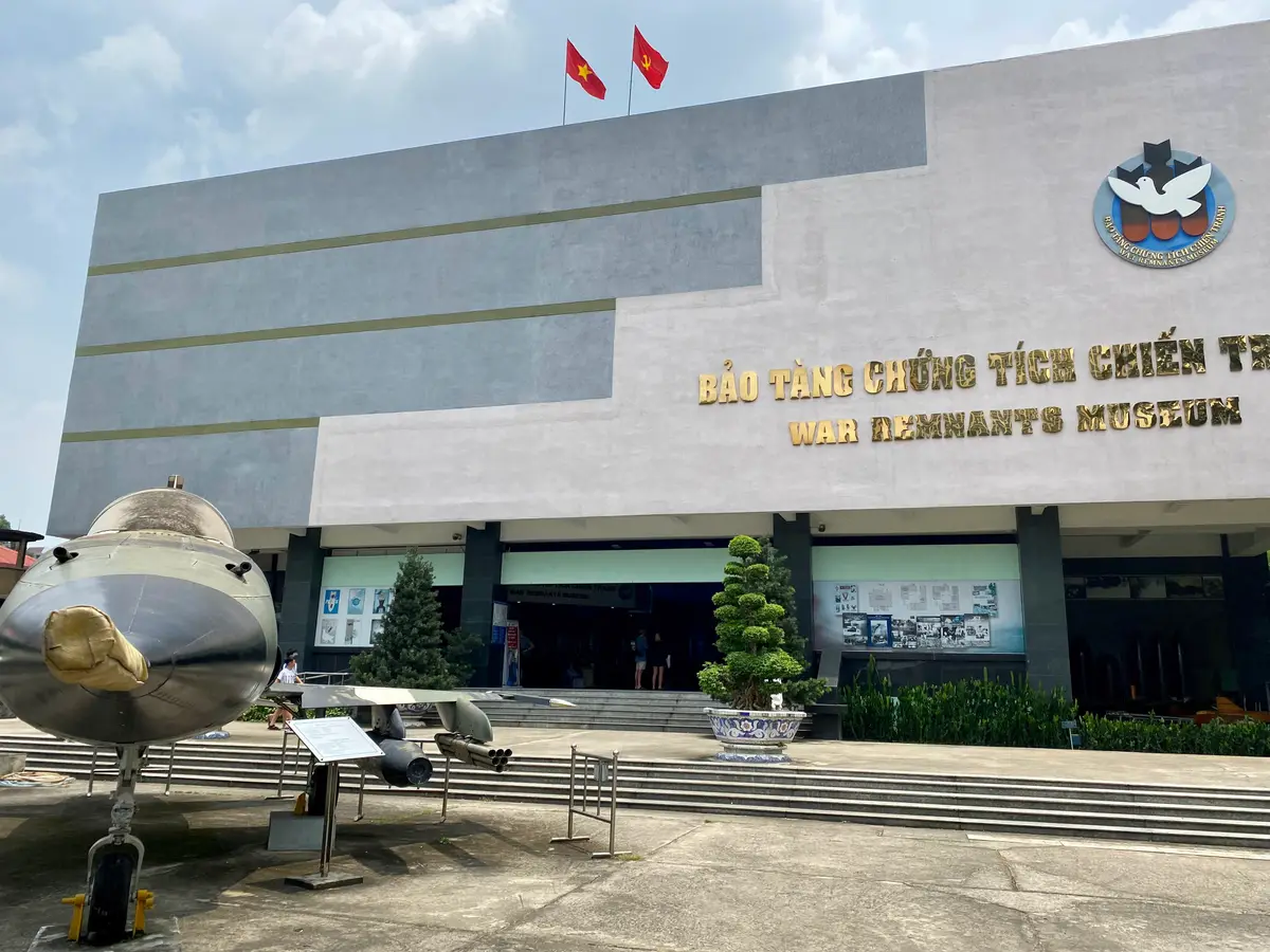 Museum front with gold lettering above the entrance and a jet aircraft parked in the forecourt