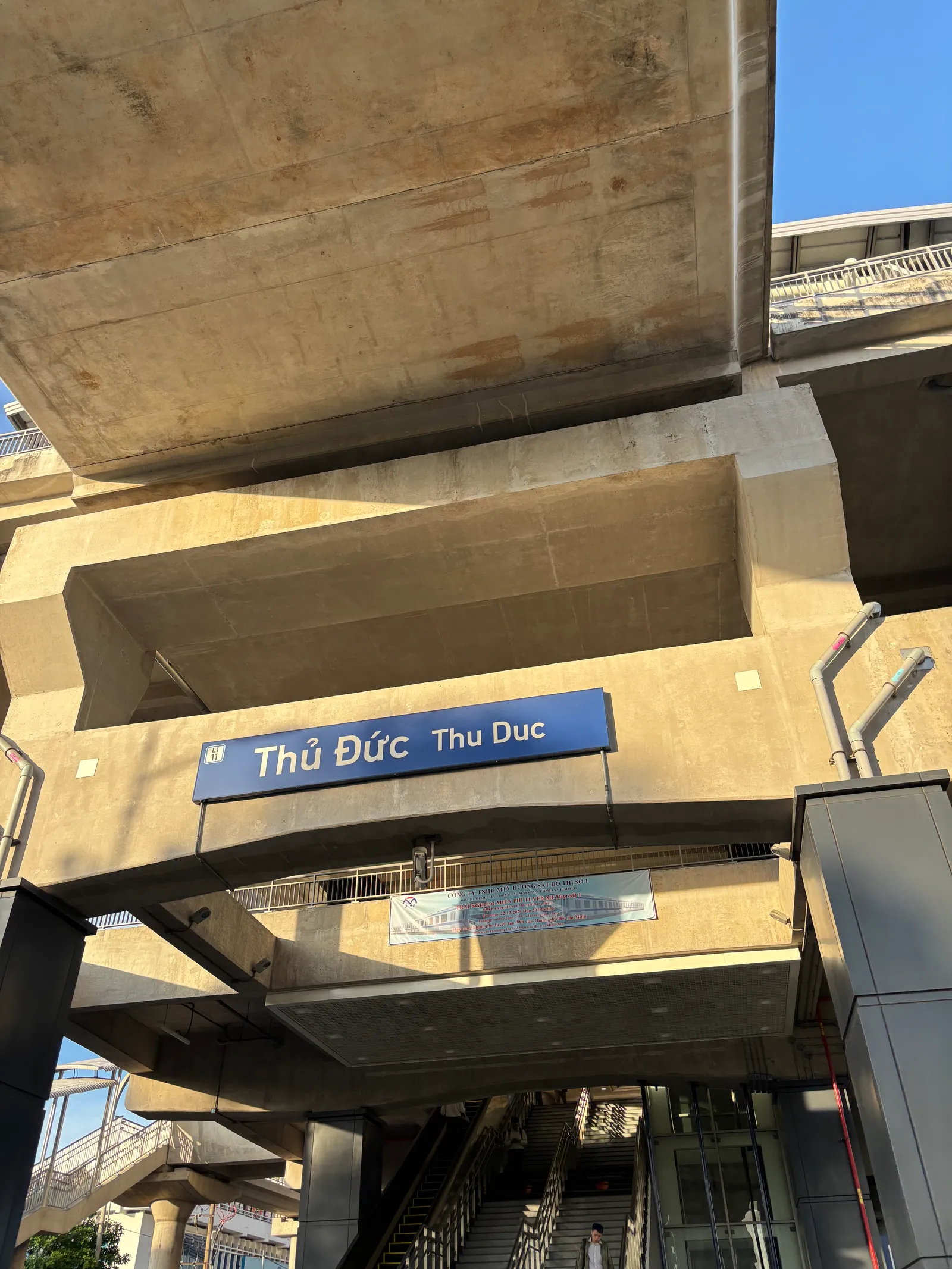 Elevated metro station sign reading Thu Duc under a concrete viaduct